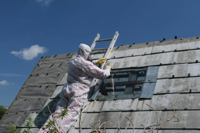 Arbeiter entfernen Asbestplatten vom Dach